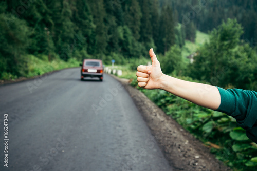 Hand of hiker woman at rural mountain road.