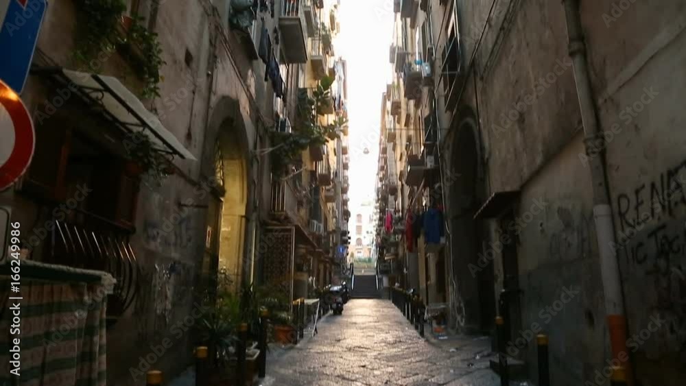 View of narrow passage between high walls of houses in Naples street, Italy View of narrow passage between high walls of houses in Naples street, Italy