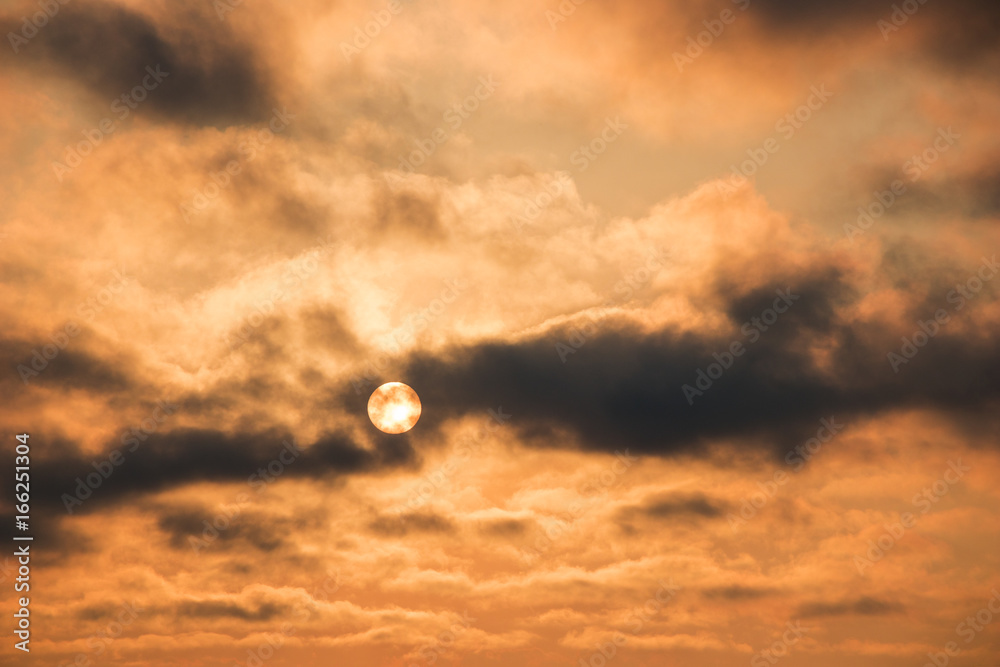 orange sky with smoky clouds at sunset moving over the sun orange sky with smoky clouds at sunset moving over the sun