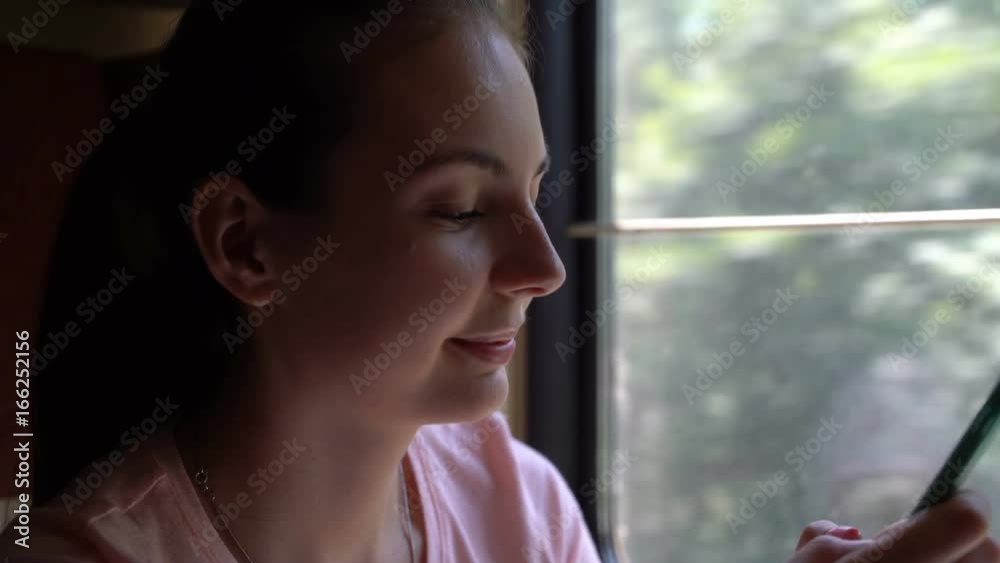 girl travels by train and uses the application on her smartphone. girl travels by train and uses the application on her smartphone.