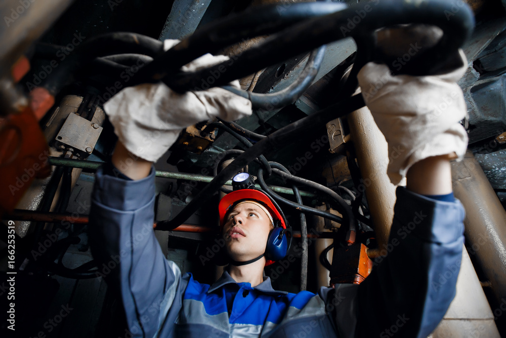 man in the underground mine repairs the hydraulic pipes. Concept work in difficult conditions. man in the underground mine repairs the hydraulic pipes. Concept work in difficult conditions.