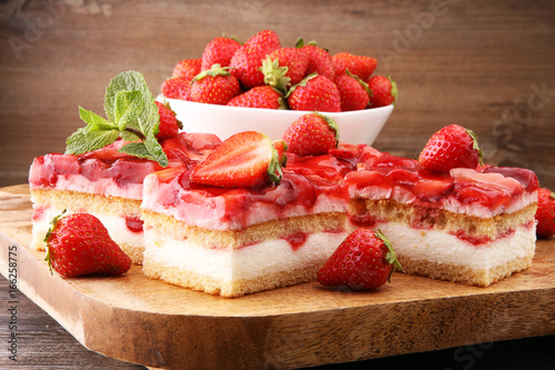 strawberry cake on wooden board with fresh strawberries
