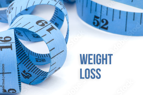 Weight loss, health concept, close up & selective focus of blue measuring tape, isolated on white background
