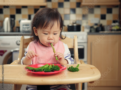 baby girl eating food at home