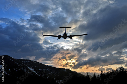 passenger plane flies in juicy clouds to meet the sun.