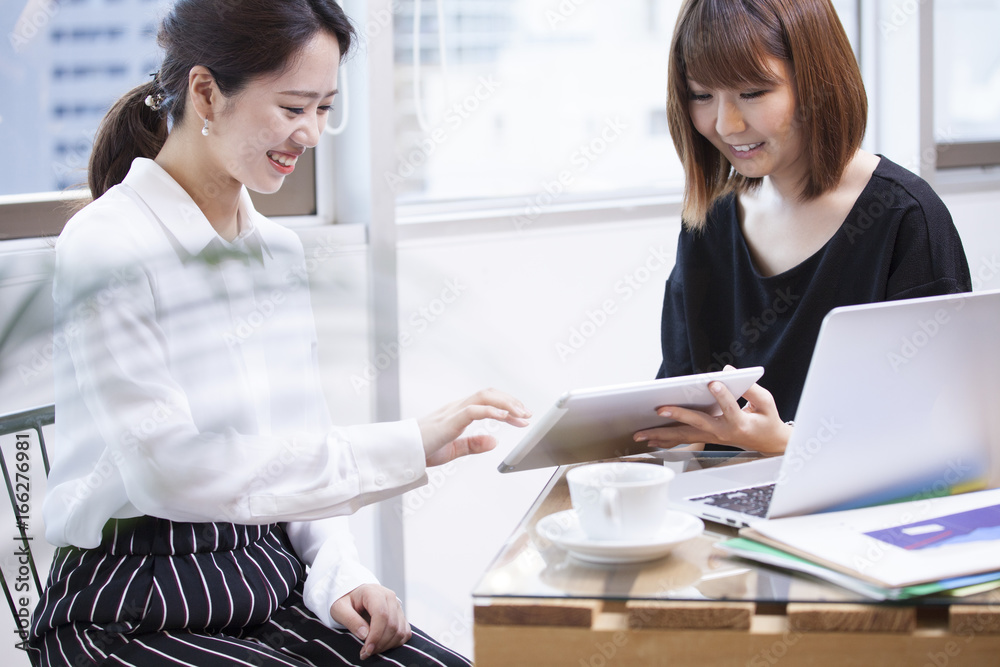 Women are laughing at the electronic tablet Women are laughing at the electronic tablet
