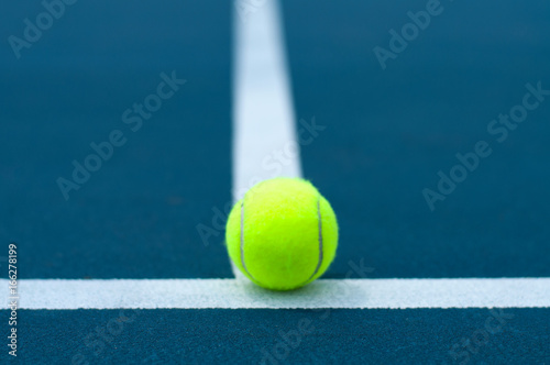 Tennis ball on tennis court with white line © Dmytro Flisak