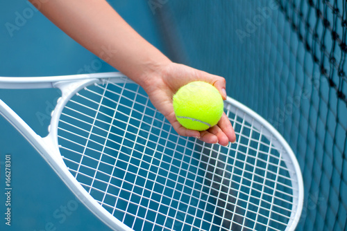 Tennis player holding tennis ball in hand  on the tennis court © Dmytro Flisak
