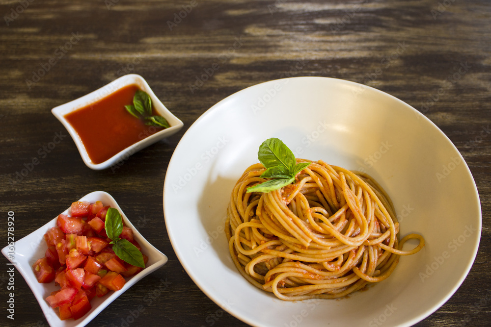 Spaghetti with tomato and basil on wooden background