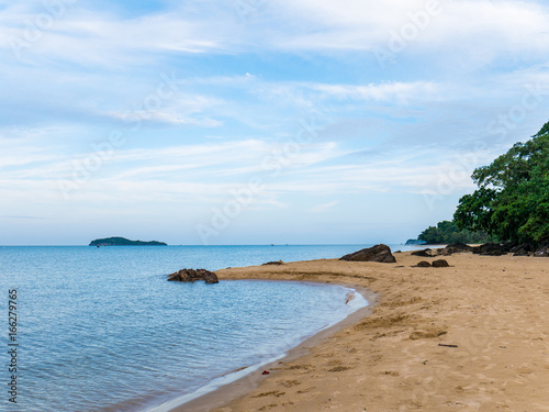 Tranquil scene of sand beach and curved coastline at sunset and blue sky