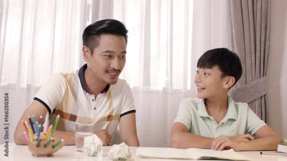 surprised Asian father & son cheering at writing book surprised Asian father & son cheering at writing book