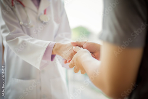 doctor comforting and hold patient hand in hospital