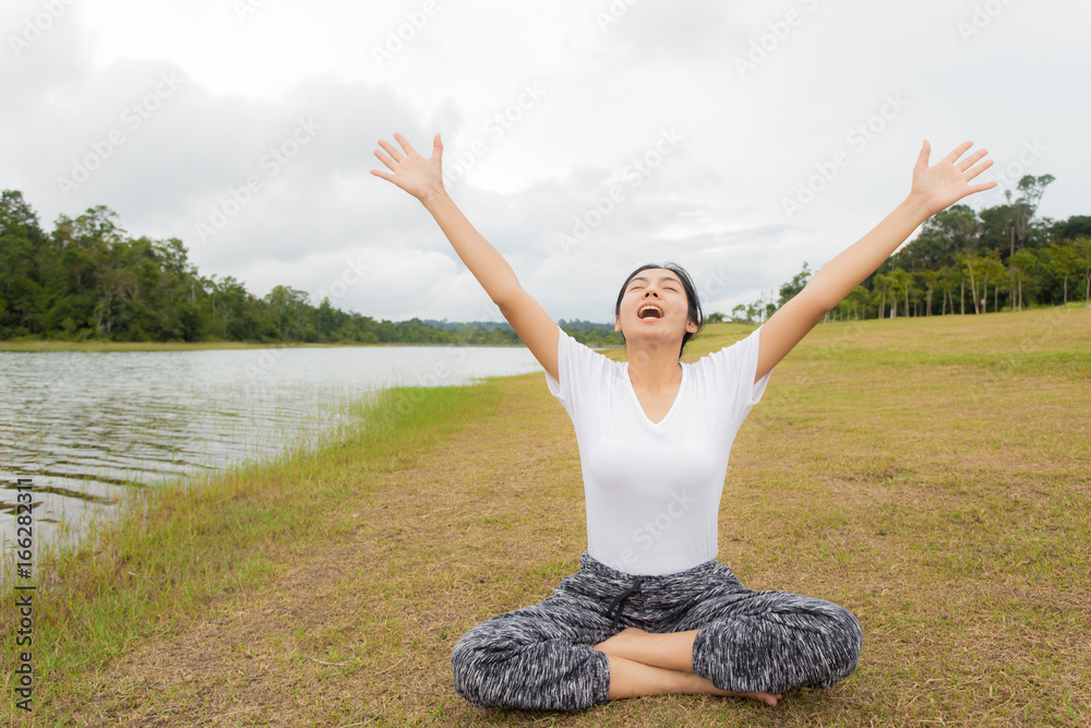 Young asian woman enjoying and relaxing on the green grass Young asian woman enjoying and relaxing on the green grass