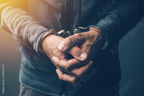 Fotografering Arrested computer hacker with handcuffs