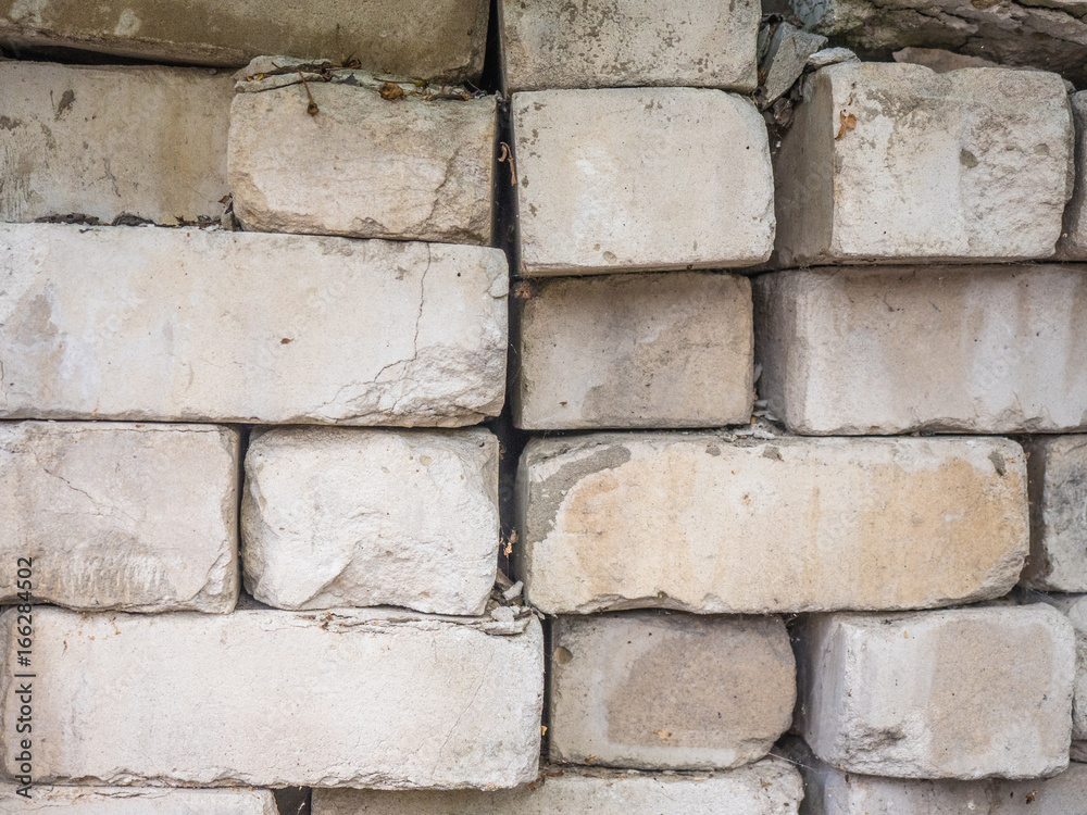 White calcium silicate bricks piled on top of each other. Old, cracked and chipped brick built, rough stack. The texture of the brick close-up. White calcium silicate bricks piled on top of each other. Old, cracked and chipped brick built, rough stack. The texture of the brick close-up.