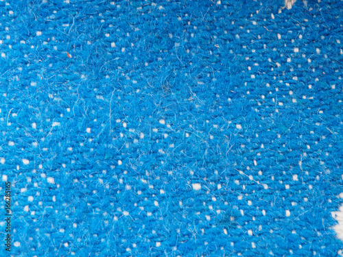 A full page of blue synthetic faux material. Macro sweater, knitted wool texture. View of top on background texture. Braided wool texture closeup