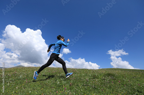 young fitness woman runner running jumping on grassland © lzf