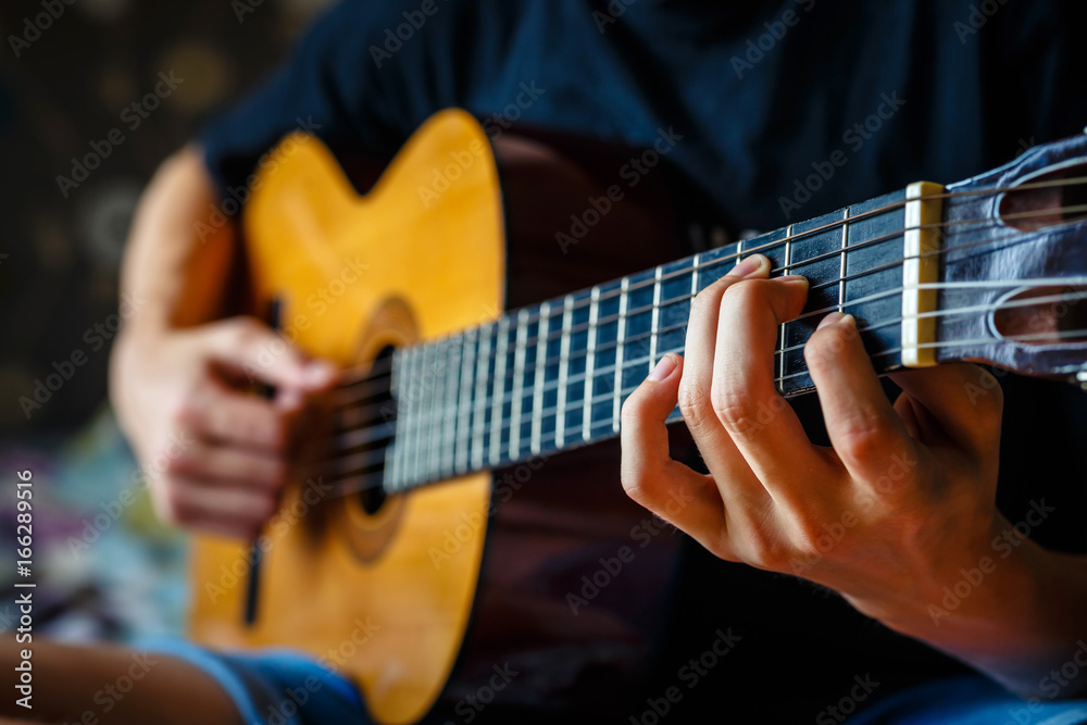 Fototapeta premium young musician playing acoustic guitar, live music background