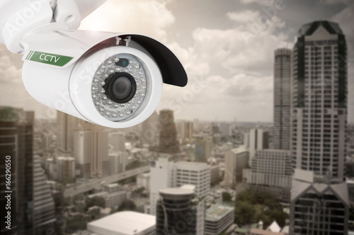 CCTV, security camera on building city background.