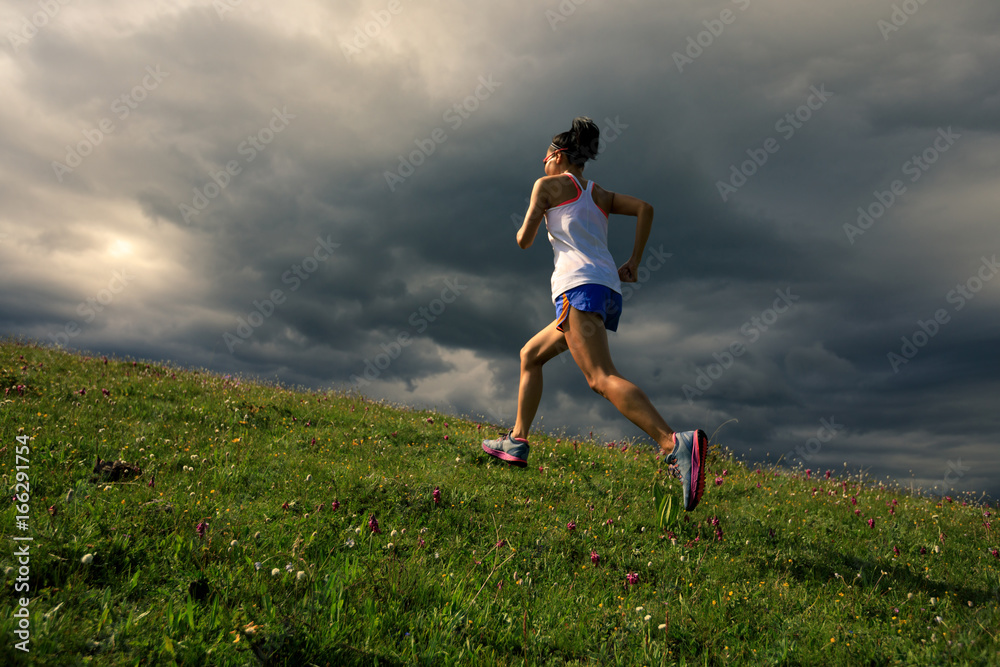 young fitness woman runner running on grassland