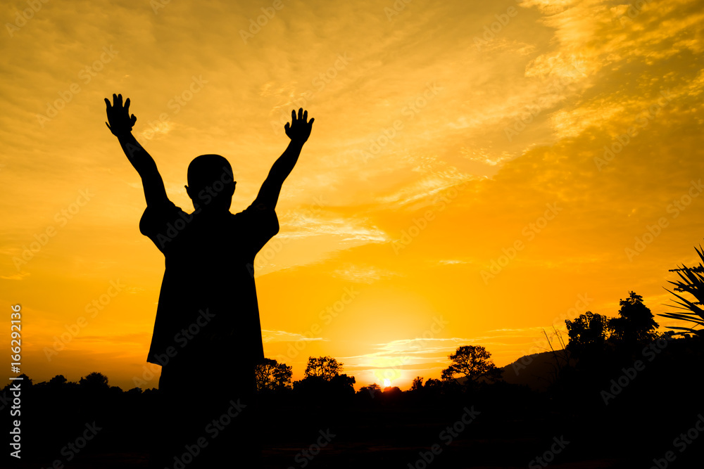 the boy hold right and left hand for greet sign. action of people silhouette with orange sky in the evening for abstract background.