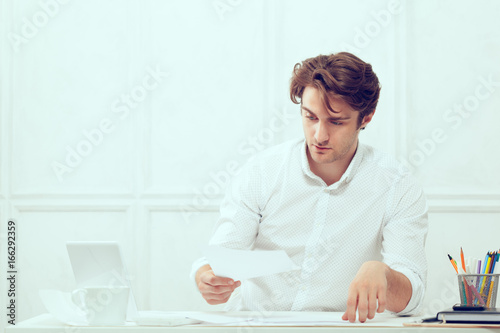 Businessman using laptop with tablet and pen