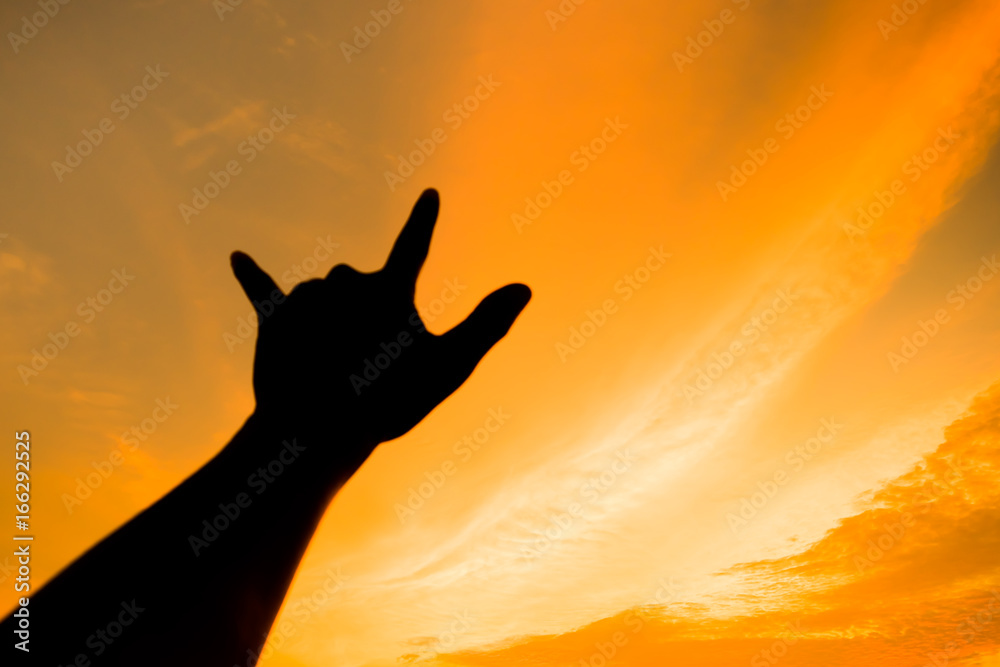 the left hold hand for I Love You sign. action of people silhouette with orange sky in the evening for abstract background.