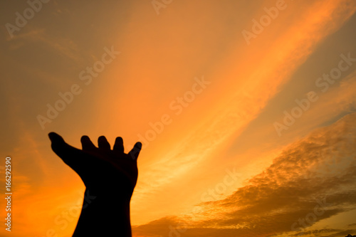 hold left hand. action of people silhouette with orange sky in the evening for abstract background.