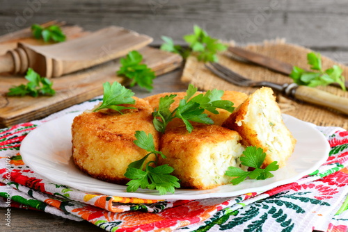 Mixed vegetable cutlets with egg filling on a white plate. Fried cauliflower potato cutlets with egg filling. Homemade vegetarian zrazy recipe. Rustic style. Closeup