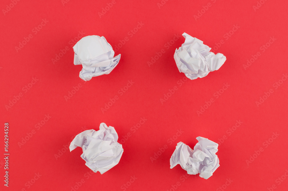 Obraz premium Four white crumpled papers on red paper background