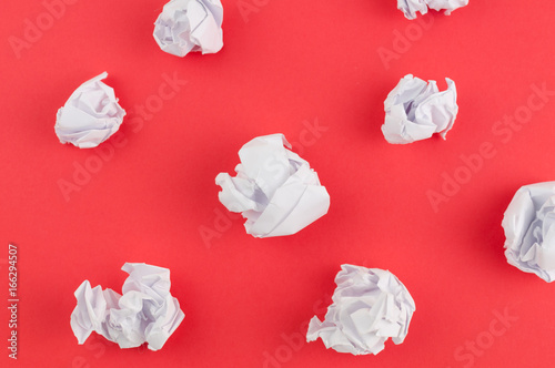 Many white crumpled papers on red paper background