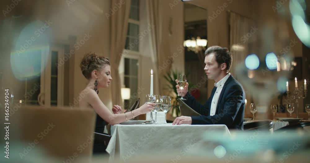 young couple with a glass of wine in the restaurant , first date young couple with a glass of wine in the restaurant , first date