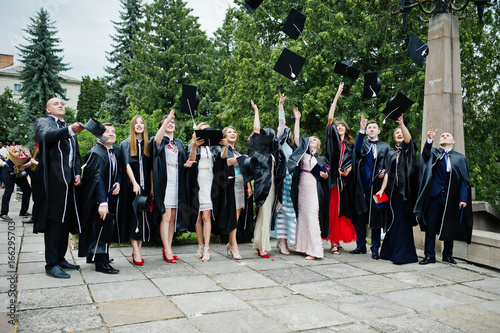 Happy university graduates throwing their graduation caps into the air.