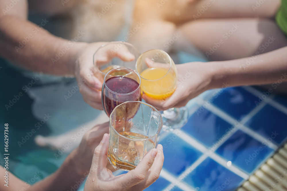Friends having party  in a swimming pool. Young people are enjoying the holidays.