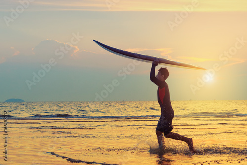 Photography Man running with surfboard on the beach.