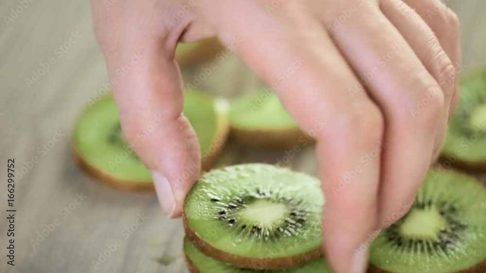 Slicing orgenic kiwi on wood cutting board