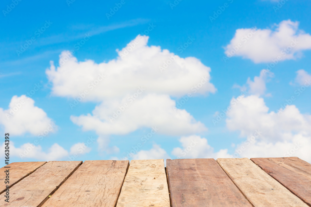 perspective old wooden board empty table in front of blur background of bright cloudy sky, can be used for display or montage your products. Mock up for displaying product.