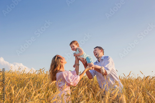 happy family in cereal field at sunset