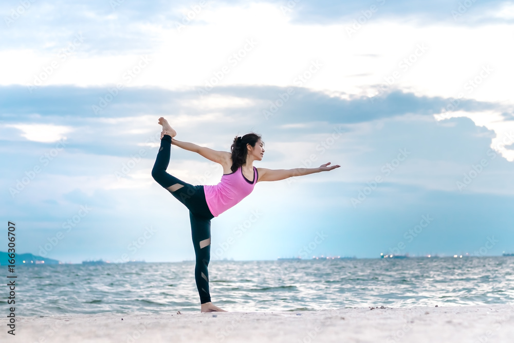 Young asian yoga exercise with posting on the beach in summer outdoor