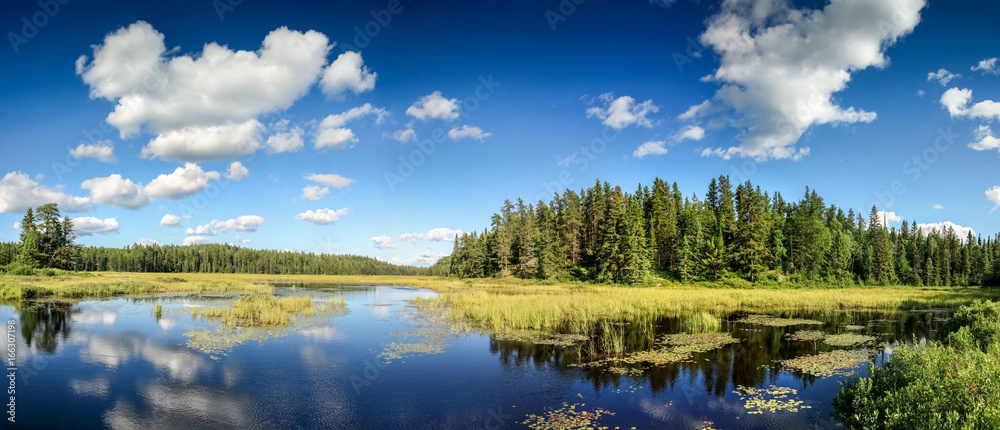 Obraz premium Blue mirror lake reflections of clouds and landscape. Ontario, Canada.