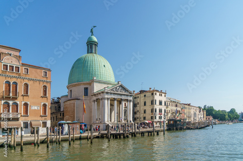 Venice with Grand canal, basilica, colorful buildings and walking tourists.