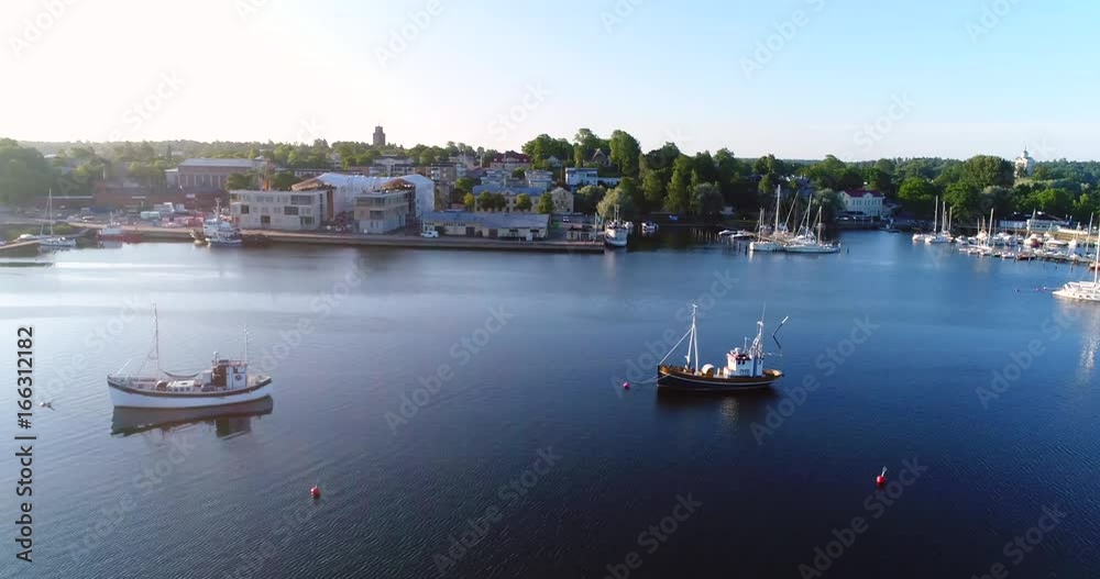 Fishing boat in a city, Cinema 4k aerial sideway view of fisherboats in front of Ekenas city, on a sunny morning, in Tammisaari, Uusimaa, Finland Fishing boat in a city, Cinema 4k aerial sideway view of fisherboats in front of Ekenas city, on a sunny morning, in Tammisaari, Uusimaa, Finland
