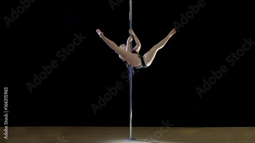 Pole Dance.Young blond woman showing fragments of dance on a black background