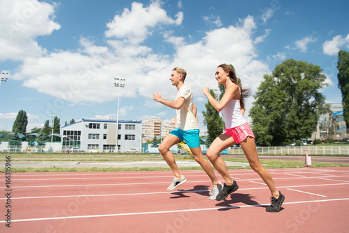 Couple running on arena track.
