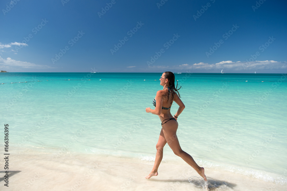 Woman in bikini running on beach