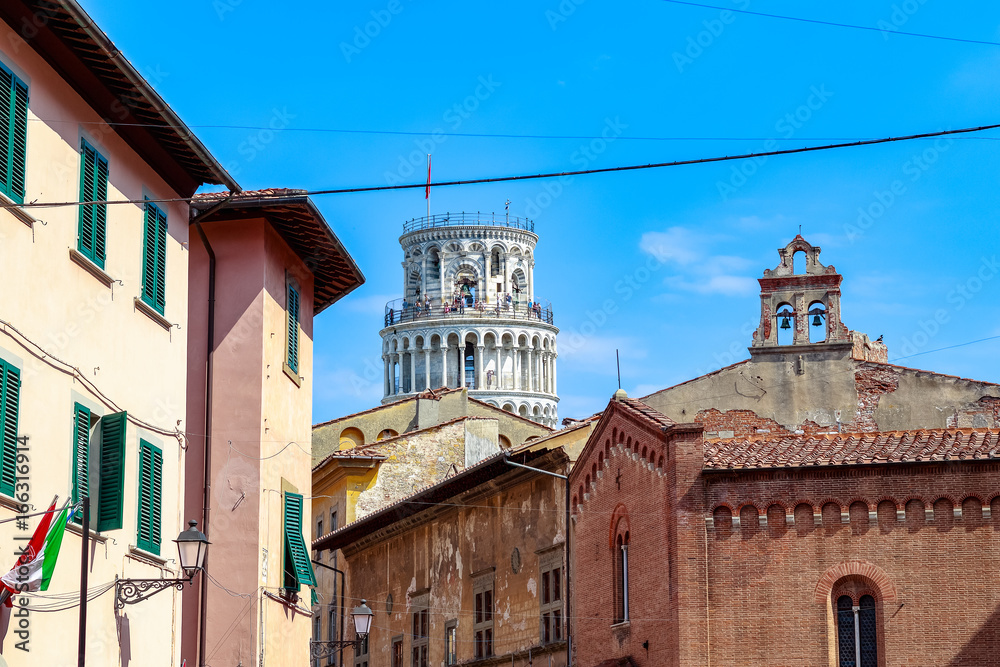 The Leaning Tower of Pisa seen amid typical local buildings in Italy
