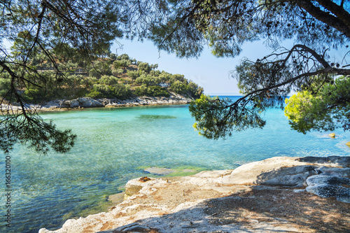 Landscape image of meditteranean lagoon with beautifil blue green sea, rocks and evergreen trees