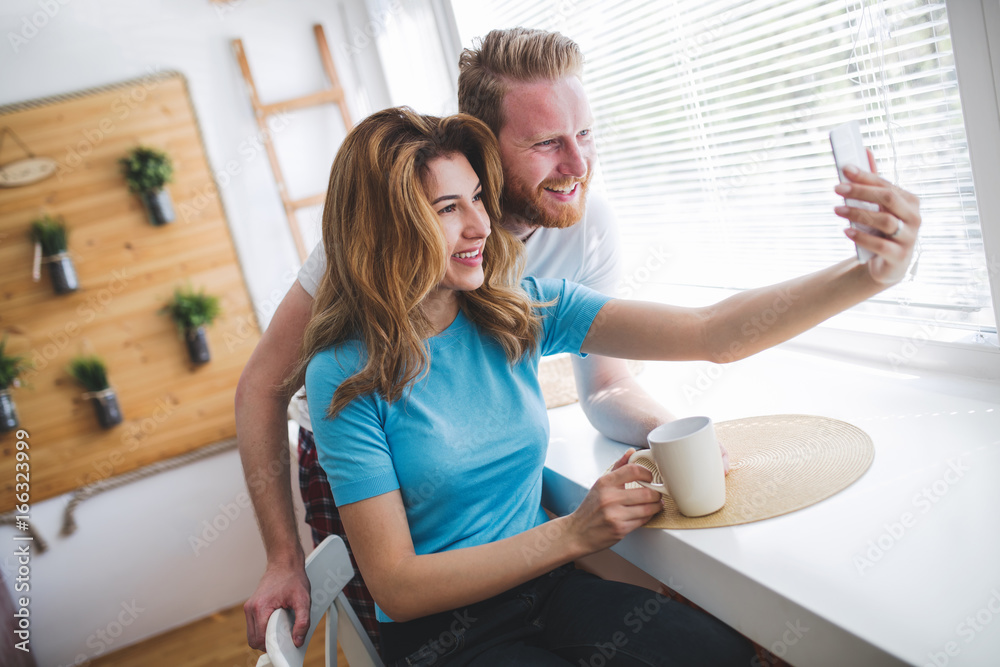 Couple taking selfies and smiling at hime