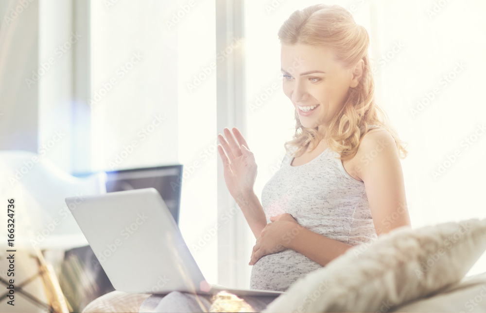Joyful pregnant woman talking through the Internet Joyful pregnant woman talking through the Internet