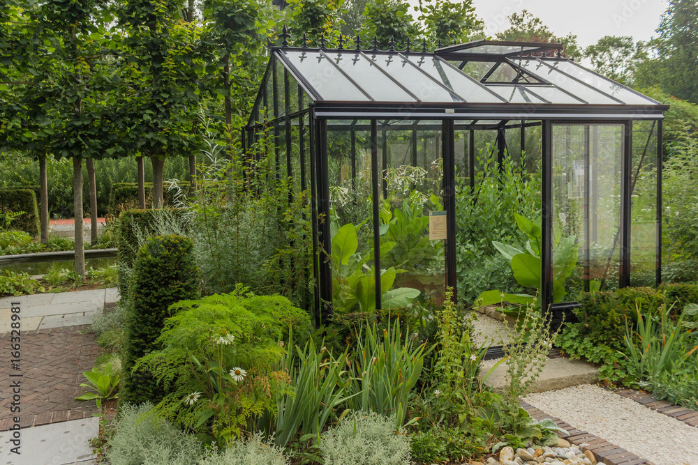 A greenhouse in a small cozy garden.